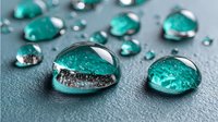 Transparent turquoise water drops on gray surface with reflections and bubbles, showing surface tension and purity for environmental or wellness concepts.