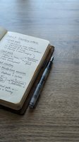 Open notebook with handwritten notes and pen on wooden desk surface for business planning and goal setting productivity concepts.