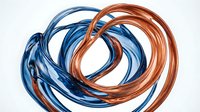 Abstract twisted copper and blue metal wires forming dynamic spiral loops on white background for modern design projects and industrial concepts.
