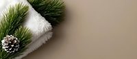 Pine branch with silver pinecone and white knitted scarf on neutral beige background, winter holiday spa and wellness composition for relaxation and comfort.