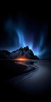 Dramatic northern lights aurora borealis dancing over snow-capped mountain peaks with winding coastline and starry night sky creating magical winter landscape.