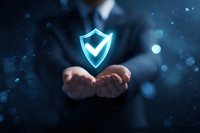 Businessman holding glowing blue shield with checkmark, symbolizing cybersecurity protection and digital data safety in corporate environment.