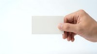Hand holding blank white business card mockup on clean background for branding and corporate identity design projects.