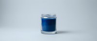 Blue candle in clear glass jar on white background, aromatherapy home decor product isolated for commercial use and design projects.