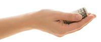 Hand holding rolled dollar bills on white background, isolated for financial and business design use.