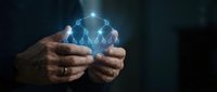 Businessman hands holding glowing digital network connection icons representing teamwork collaboration and business connectivity in dark background.