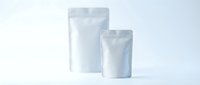 Two white blank stand-up pouches with zip closure on clean background for product packaging mockup and branding design applications.