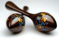 Traditional wooden maracas with colorful folk art floral patterns on white background. Handcrafted percussion instruments for music and cultural celebrations.