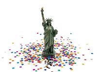 Statue of Liberty standing on colorful confetti scattered across white background, symbolizing celebration, freedom, and patriotic festivity for holiday and event design projects.