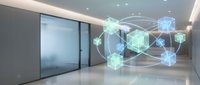 Modern office interior with holographic blockchain network visualization displaying connected digital cubes and data nodes in corporate lobby space.