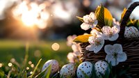 Fresh spring composition with painted Easter eggs and blooming cherry blossoms in wicker basket against sunset bokeh background, creating magical atmosphere.