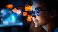 Young woman wearing glasses with colorful bokeh lights reflection creating atmospheric night portrait for technology and lifestyle concepts.