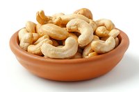 Roasted cashew nuts in terracotta bowl isolated on white background, suitable for food packaging, culinary websites, and healthy snack marketing materials.