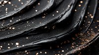 Macro shot of black textured waves with scattered copper glitter particles creating luxurious abstract pattern on dark background. Elegant minimal composition.