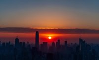 Stunning sunrise over city skyline with dramatic orange and purple sky. Urban landscape silhouette against golden sun. Corporate business backdrop concept.