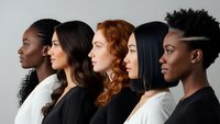 Diverse group of five professional women in profile view showcasing different ethnicities and hairstyles in modern business attire against neutral background.