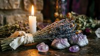 Dried lavender bundle with healing crystals and burning candle creating mystical atmosphere for meditation, aromatherapy and spiritual wellness practices.