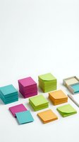 Stacks of colorful adhesive notes in turquoise, magenta, lime green, and orange arranged on white background, isolated for office supplies and stationery design use.