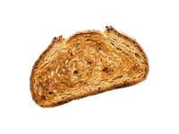 Toasted bread slice with crispy golden-brown exterior and visible texture, isolated on white background, suitable for food, bakery, and culinary design projects.