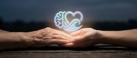 Glowing heart symbol floating above cupped hands representing love, care, protection and emotional support in warm lighting against blurred background.