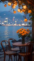 Romantic waterfront cafe setting with orange roses in vase, string lights above, and city lights reflecting on water. Wooden bistro chairs and round table create intimate atmosphere.
