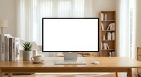 Modern home office workspace with blank computer monitor on wooden desk, bookshelf and natural lighting for productivity and remote work setup.