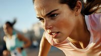 Young athletic woman in pink tank top during intense workout, sweating and focused with determined expression, outdoor fitness training at sunset.