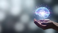 Digital brain hologram floating above open palm with glowing neural networks and data connections representing artificial intelligence and cognitive technology.