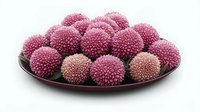 Pink chrysanthemum flowers arranged on dark ceramic plate against white background, fresh floral composition isolated for decorative and design purposes.