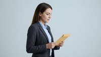 Young professional woman with dark hair and light skin tone wearing dark business blazer, holding tablet device, isolated on white background for corporate and business applications.