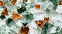Shattered glass fragments in green, amber and clear colors create abstract mosaic pattern with light shining through crystalline shapes. Suitable for modern design backgrounds.