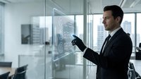 Professional businessman in suit presenting data analytics on interactive glass screen in modern office environment for corporate presentations.