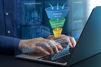 Business professional using laptop with digital marketing funnel hologram showing conversion optimization and sales performance analytics in modern office.