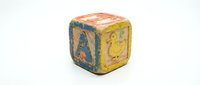 Vintage wooden alphabet block with colorful letters and illustrations on white background, perfect for educational toys, childhood memories, and learning concepts.
