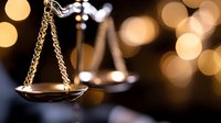 Scales of justice with warm bokeh lights creating elegant legal concept for law firm branding and judicial system representation.