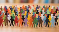 Colorful paper cutout people figures standing together, representing diversity, inclusion, and community unity in a vibrant crowd concept.