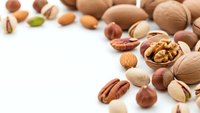 Mixed nuts and seeds collection on white background for healthy snacking and cooking ingredients with copy space for text design.