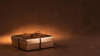 Wrapped gift box with rope on dark brown background with warm golden lighting, suitable for holiday, celebration, and packaging design projects.