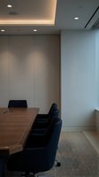 Modern corporate conference room with wooden table, navy chairs and minimalist lighting design for business meetings and professional presentations.