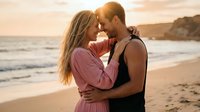 Young couple embracing intimately on beach at golden hour sunset, romantic moment by ocean waves, love and connection concept for lifestyle content.
