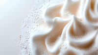 Close-up of white whipped cream swirl with delicate foam bubbles on light background for culinary and dessert design projects.