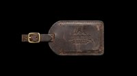 Vintage brown leather luggage tag with brass buckle strap, isolated on transparent background. Ready for t-shirt design, clipart, stickers, print-on-demand products, and sublimation projects.