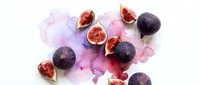 Fresh purple figs cut in half showing red flesh on white background with watercolor splashes for culinary and healthy eating concepts.