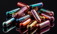 Colorful glass medicine capsules with liquid inside on reflective black surface, pharmaceutical concept showing drug development and medical research.