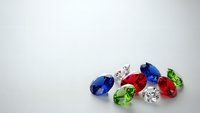 Colorful precious gemstones collection with sapphire, emerald, ruby and diamond stones scattered on white background for luxury jewelry design.