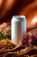 Blank aluminum beverage can mockup surrounded by pink flowers and dried herbs on brown silk fabric background, soft lighting creates elegant product display.