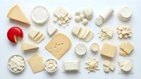 Assorted cheese varieties arranged on white background including hard soft aged fresh types perfect for culinary food photography and cooking content.