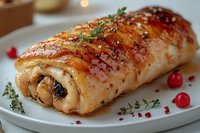 Glazed chicken roulade stuffed with mushrooms and herbs, garnished with fresh thyme and red currants on white plate, close up view of gourmet main course.