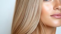 Close up portrait of young blonde woman with natural makeup and glowing skin showing part of face against light background. Suitable for beauty and skincare advertising.