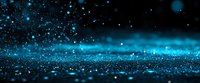 Magical blue glowing particles and sparkles floating in dark space with bokeh effect, creating mystical atmospheric background for fantasy designs.